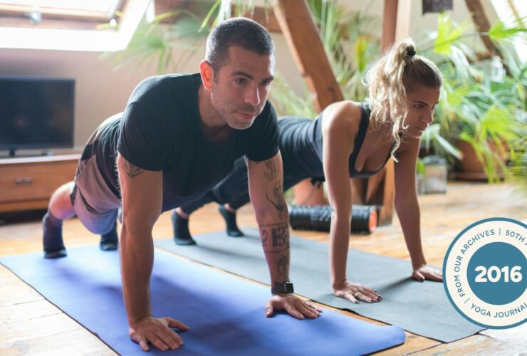 People in Plank pose on yoga mat.