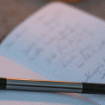 An open writing journal with a pen