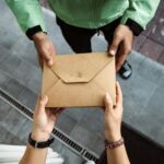 Close-up of two people exchanging cardboard box of food.