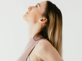 Woman in pink shirt standing with her shoulders drawn back.