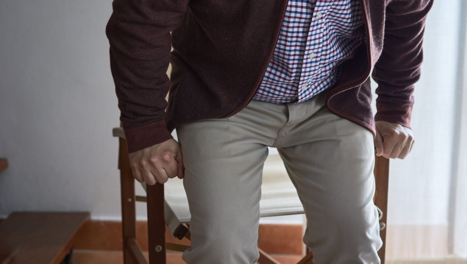 an older adult has difficulty getting up from an chair in the living room