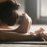 Close-up of woman stretching in standing forward bend.