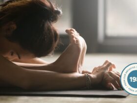 Close-up of woman stretching in standing forward bend.