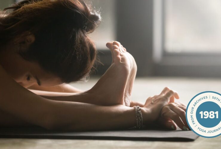 Close-up of woman stretching in standing forward bend.