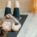 Woman lying on back on yoga mat.