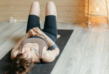 Woman lying on back on yoga mat.