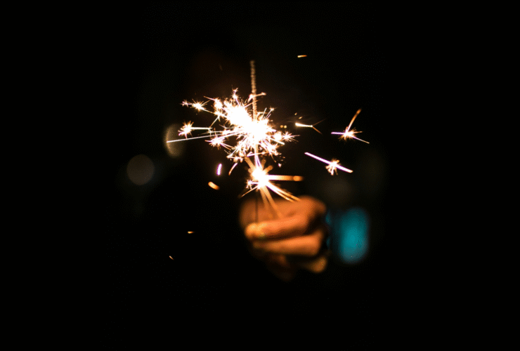 Woman holding a sparkler outside in the night sky