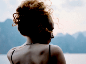 Woman standing outside looking at mountains contemplating her weekly horoscope for December 7-13, 2025.