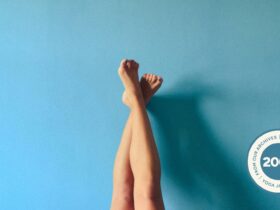 Image of person's legs crossed and resting against a light blue wall.