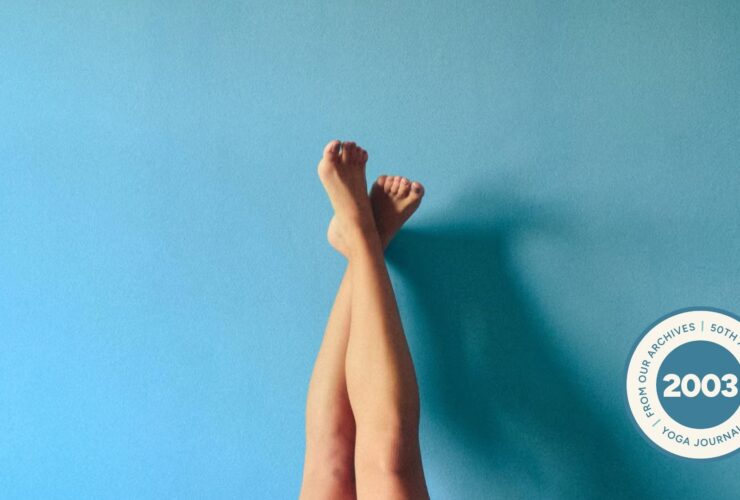 Image of person's legs crossed and resting against a light blue wall.