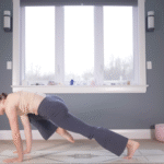 Woman in Plank Pose drawing one knee toward her nose during yoga for strength