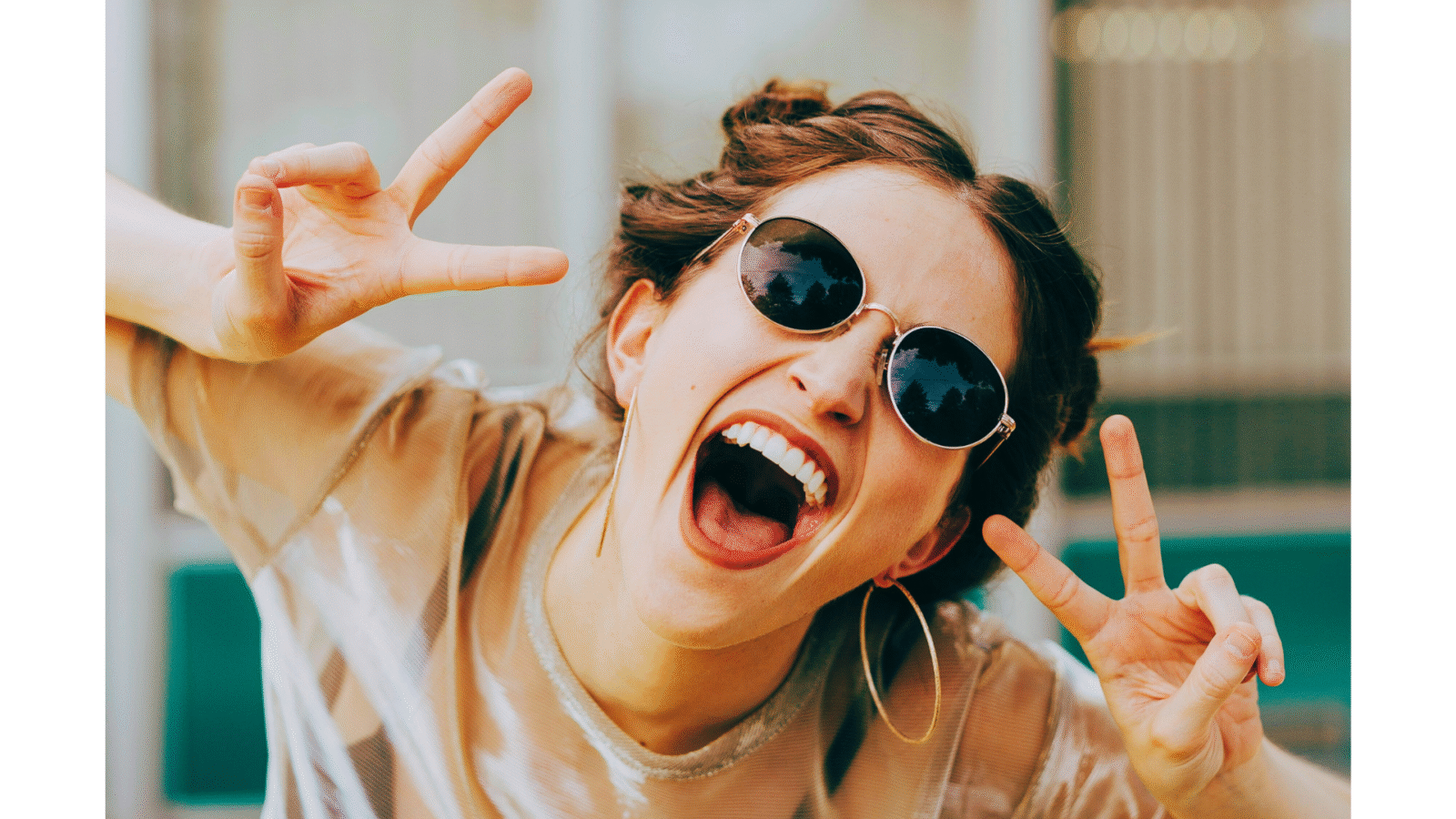 Woman wearing sunglasses and holding up peace fingers about no new years resolutions 2026