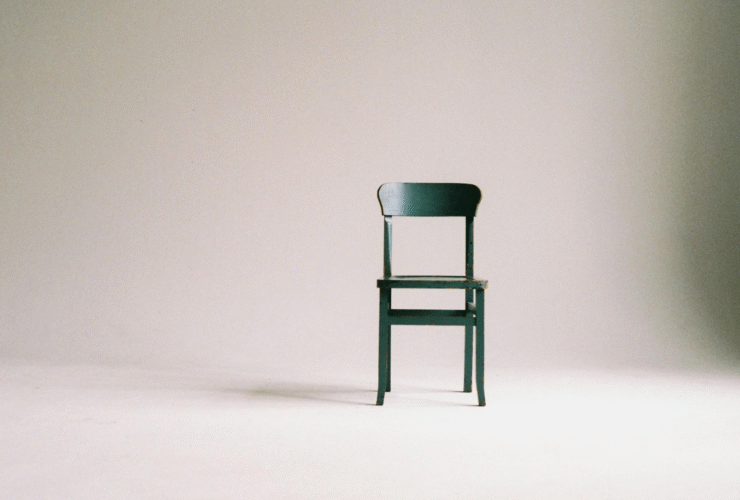 A wooden chair sitting against a wall in preparation for a chair yoga class