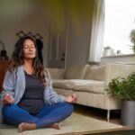 Woman sitting in Easy Pose with her hands in Gyan Mudra.