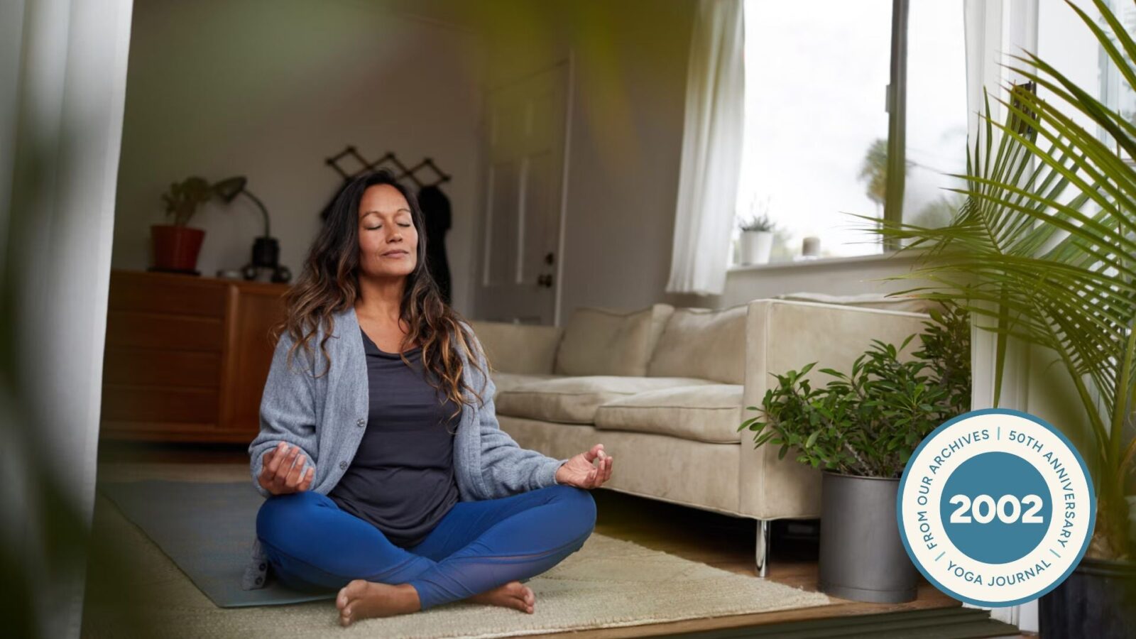 Woman sitting in Easy Pose with her hands in Gyan Mudra.