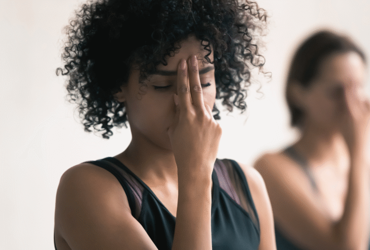 A woman demonstrating Alternate Nostril Breathing, part of her new moon yoga practice