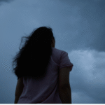 Woman standing outside beneath the new Moon in Capricorn thinking about her weekly horoscope