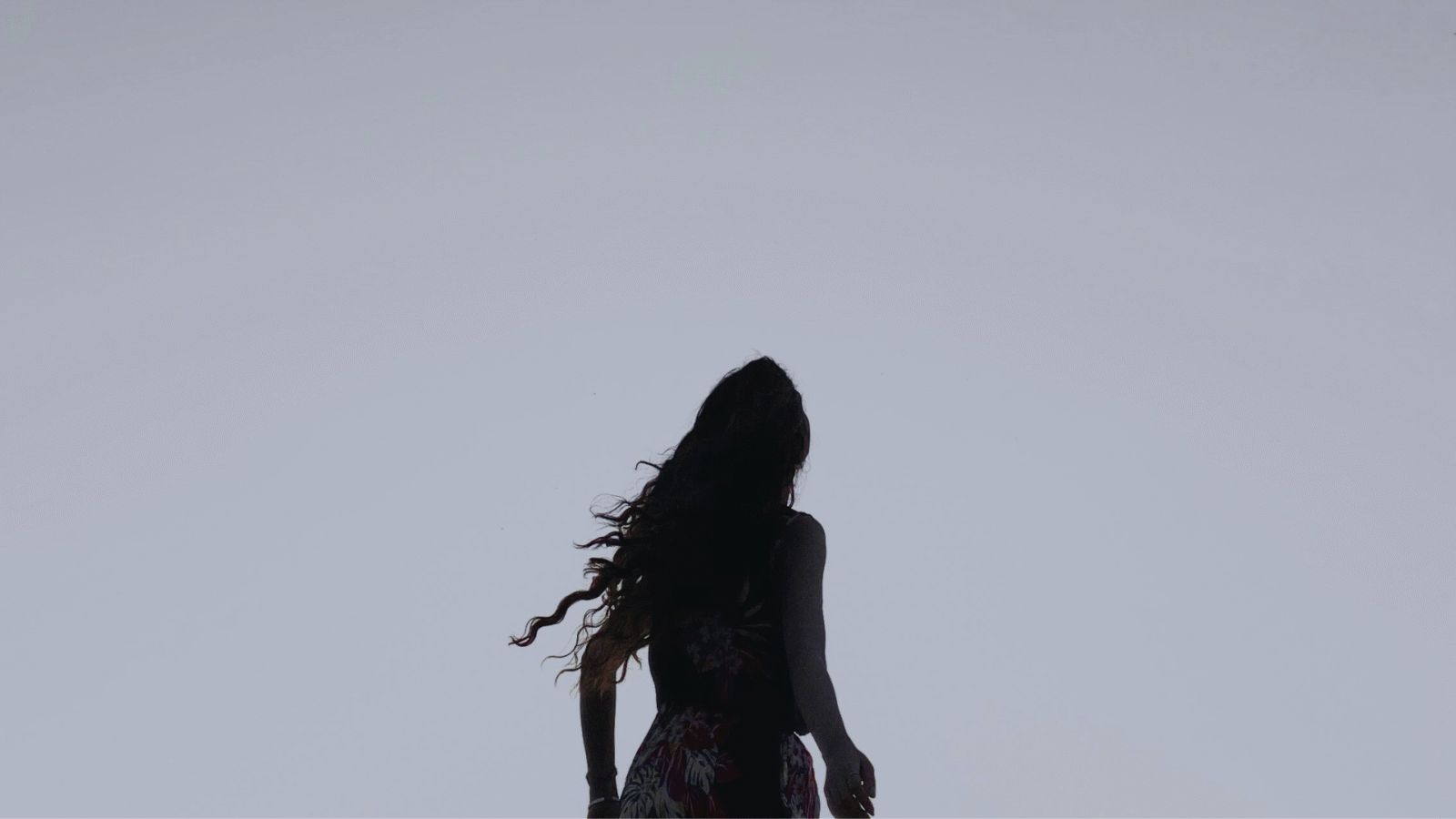 Silhouette of a woman outside during winter at dusk looking ahead and contemplating her weekly horoscope