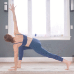 Woman in a lunge with her back knee lifted and her left hand on the mat while she twists to the right and reaches her right hand toward the ceiling