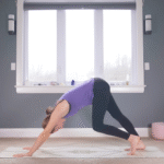 Woman in Downward-Facing Dog with one knee bent and the other straight