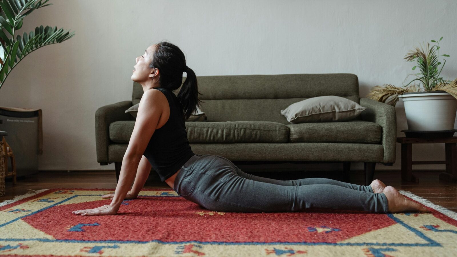 Woman practicing cobra pose at home