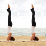 Woman practicing Headstand on the beach.