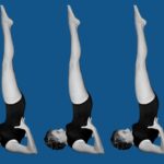 A woman in Shoulderstand against a blue backdrop