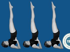 A woman in Shoulderstand against a blue backdrop