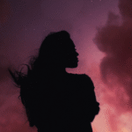 Woman silhouette in front of the blood red color of the total lunar eclipse