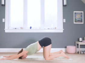 Woman kneeling on a mat with her arms stretched forward and her forehead on the mat in Puppy Pose