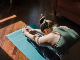 Woman practicing Forward Fold in dark room.