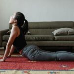 Woman practicing cobra pose at home