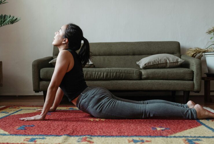 Woman practicing cobra pose at home
