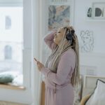 Image of woman with headphones on in robe getting ready for the day.
