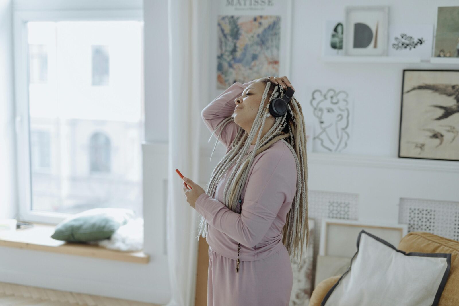 Image of woman with headphones on in robe getting ready for the day.