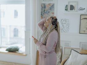Image of woman with headphones on in robe getting ready for the day.