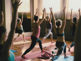 A yoga class practicing high lunge in a studio