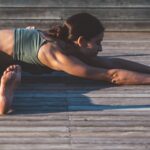 Woman practicing Seated Angle Pose outside.