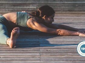Woman practicing Seated Angle Pose outside.