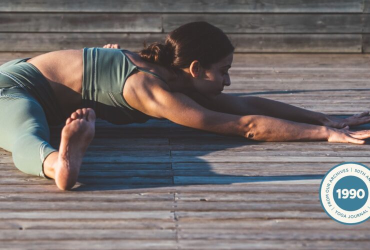 Woman practicing Seated Angle Pose outside.