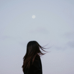 Woman silhouette against a lavender evening with a full Moon