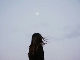 Woman silhouette against a lavender evening with a full Moon