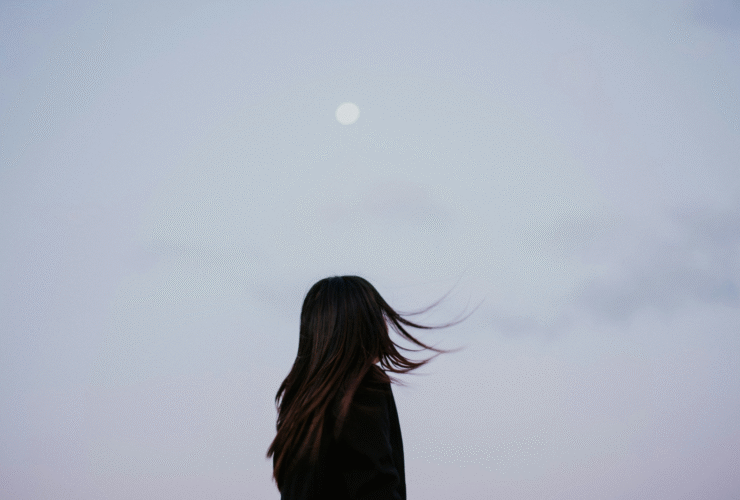 Woman silhouette against a lavender evening with a full Moon