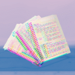 Image of a notebook containing notes for a yoga teacher on a backdrop of a yoga mat
