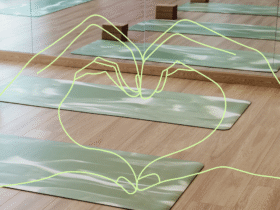 Heart hands over the backdrop of an empty yoga studio