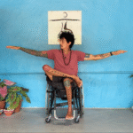 Yoga teacher in a chair in an adaptive yoga Warrior 2