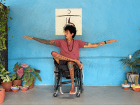 Yoga teacher in a chair in an adaptive yoga Warrior 2