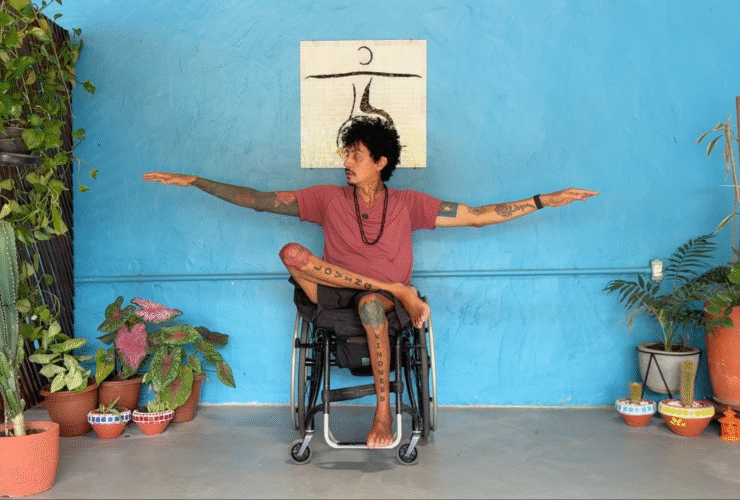 Yoga teacher in a chair in an adaptive yoga Warrior 2