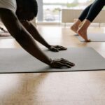 Close-up of man's hands in Downward Facing Dog in yoga class.