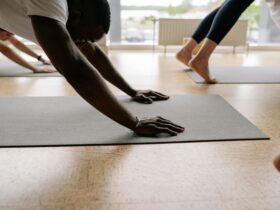 Close-up of man's hands in Downward Facing Dog in yoga class.
